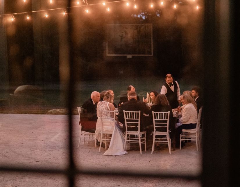 The photo is looking out a window at an intimate wedding dinner.