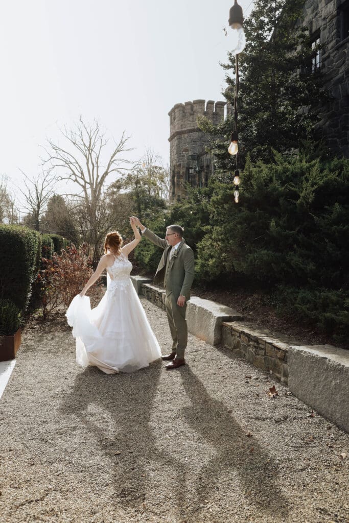 A bride and groom dance in front of a castle in Asheville.